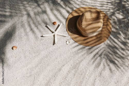 Summer vibes. Broad brim straw hat and sunglasses on a sandy beach. Copy space for text. © Evrymmnt