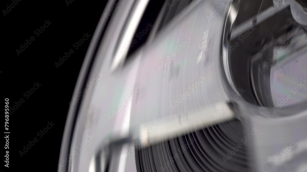closeup shot of a vintage Reel-to-reel tape recorder reel spool turning from the 60s 70s 80s 90s side view macro isolated on black background loopable for music podcasts or audio listening 4K UHD HQ