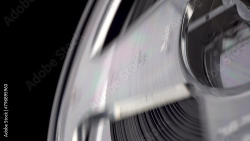 closeup shot of a vintage Reel-to-reel tape recorder reel spool turning  from the 60s 70s 80s 90s side view macro isolated on black background loopable for music podcasts or audio listening 4K UHD HQ photo