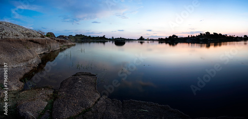 panoramic against the light of dawn in the lagoons of Los Barruecos with large granite masses photo