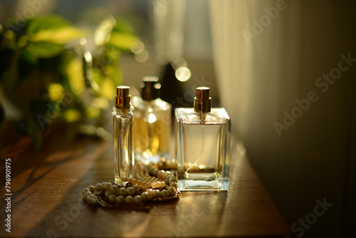 perfume bottles on a dresser by a window, seen in a soft  evening sunlight