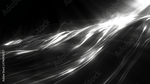   A monochrome image of light emanating from a beam against a dark backdrop