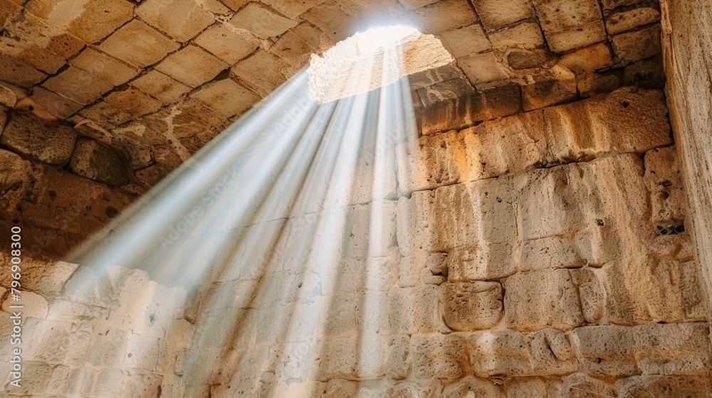   A beam of light penetrates a window in a stony wall, emanating from it, there's a light beam