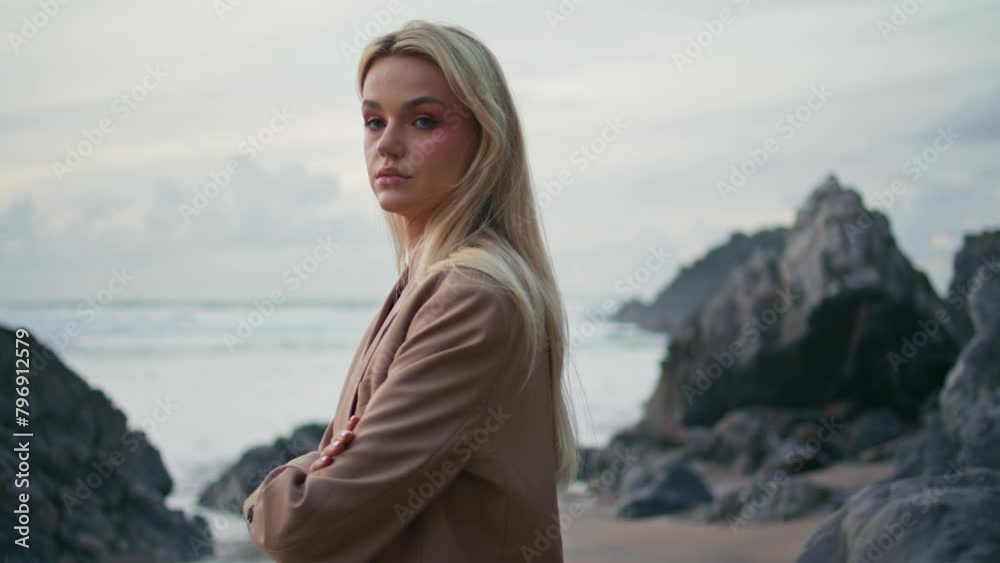 Blonde girl posing coast in gloomy evening portrait. Contemplative model turning Blonde girl posing coast in gloomy evening portrait. Contemplative model turning