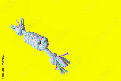 A toy for dogs on a yellow background. Braided form. Pet products