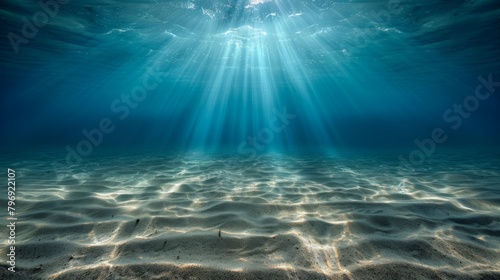 underwater background deep blue sea and beautiful light rays with sandy floor © Anastasija