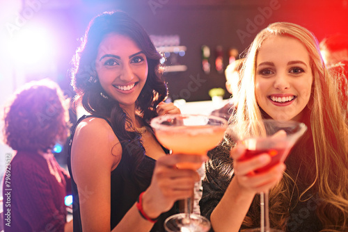 Girl, friends and cocktail with portrait with toast in nightclub, congratulations and happy hour. Women, club and drink with margarita, alcohol and smile at event in new year with cheers in night