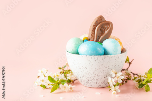 Rabbit chocolate ears and colored dragee sweets in a cup on the table. Easter concept. Copy space