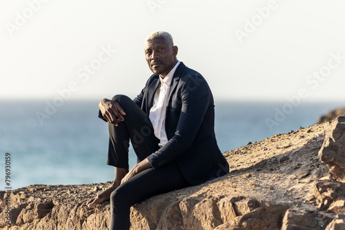 Contemplative businessman at the seaside photo