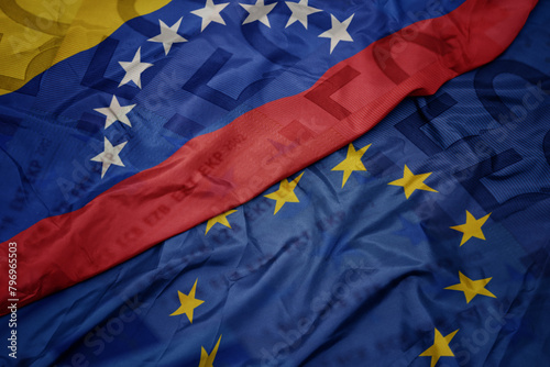 waving colorful flag of european union and flag of venezuela on a euro money banknotes background. finance concept. photo
