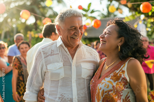 Portrait of mature Hispanic couple at family gathering outdoors in backyard in summer.