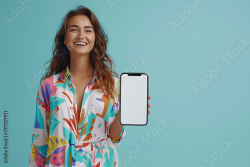 A gleeful young woman stands beside a blank mobile phone screen, her vibrant energy complementing the pastel blue setting