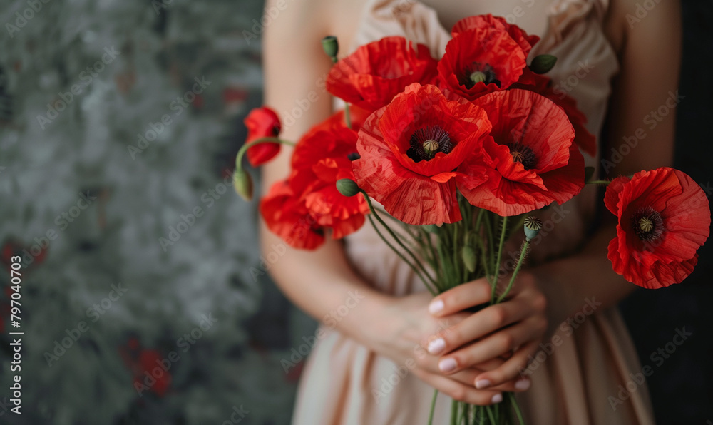 The woman holds a bouquet of red poppies in her hands, the background of which is a symbol of both memory and hope for a peaceful future.