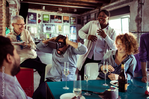 Diverse group of people celebrating a birthday and using a vr headset in a startup company office photo