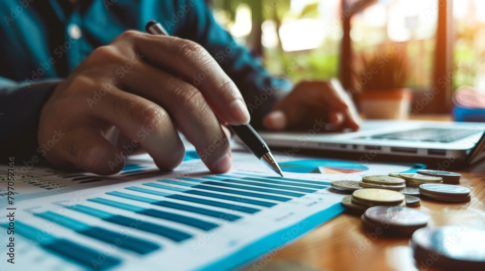 A businessman analyzing graphs and charts while using laptop. A businessman analyzing graphs and charts while using laptop.