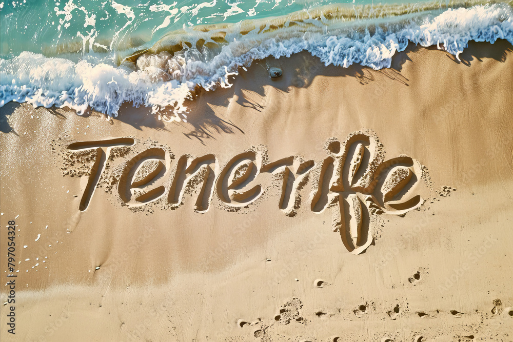 Fototapeta premium Tenerife, Spain written in the sand on a beach. Spanish tourism and vacation background