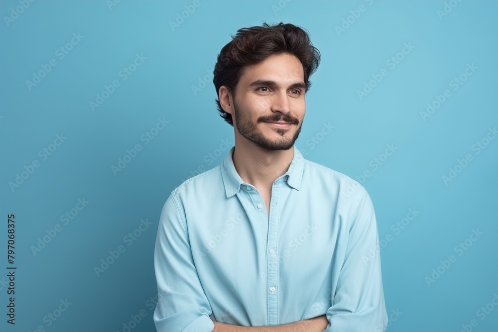 A man with a beard and a blue shirt is smiling and looking at the camera A man with a beard and a blue shirt is smiling and looking at the camera
