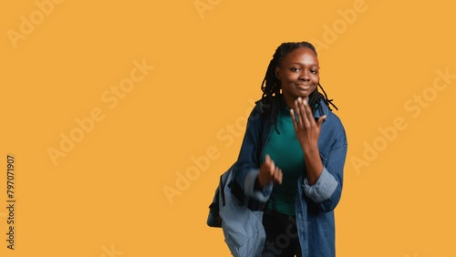 Frisky playful woman blowing kisses to camera, being flirty. Lively charming girl having fun sending air kisses, doing romantic gesturing, isolated over studio background, camera B