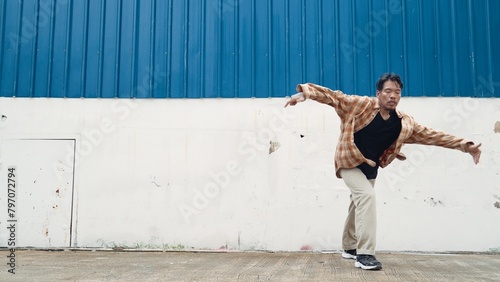 Hispanic funny choreographer dancing in hip hop style. Young happy break dancer perform b-boy dance. Motion shot of funny man practicing street dancing. Outdoor sport 2024. Modern dance. Endeavor.