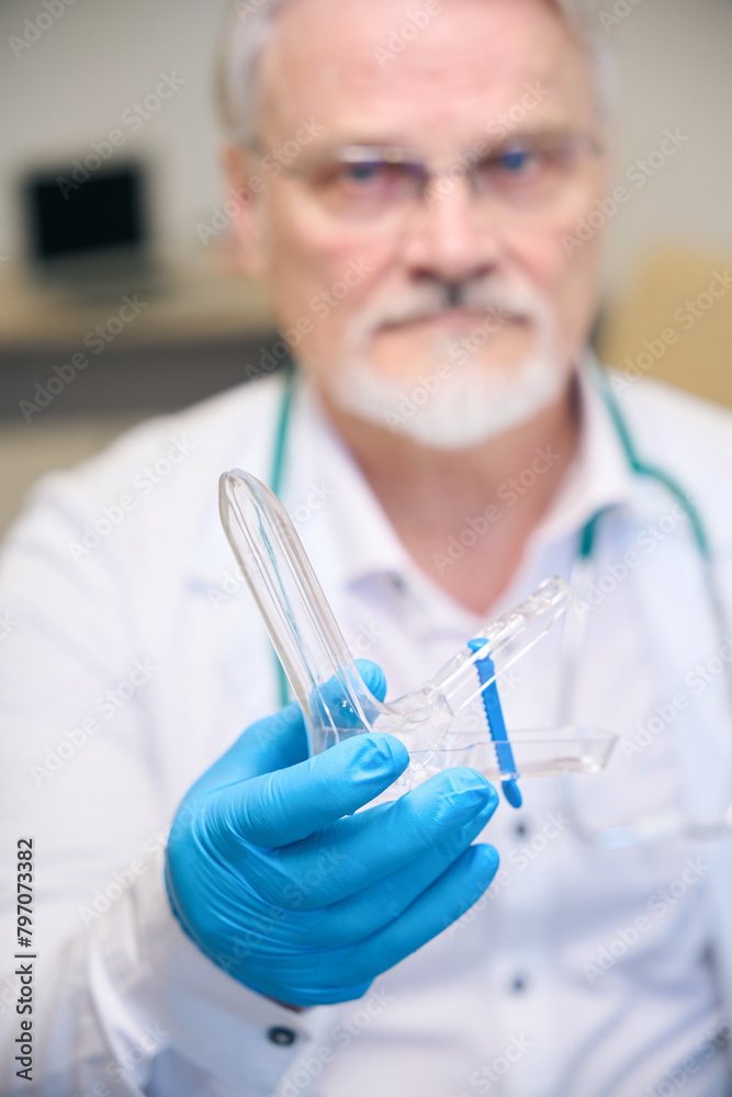 Male medic holding medical instrument in hospital Male medic holding medical instrument in hospital