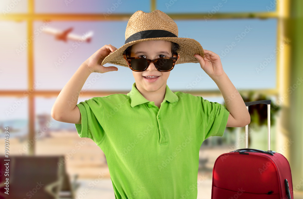 Φωτογραφία Boy on vacation wearing green t-shirt hat sunglasses at airport happy portrait smiling and looking at the camera