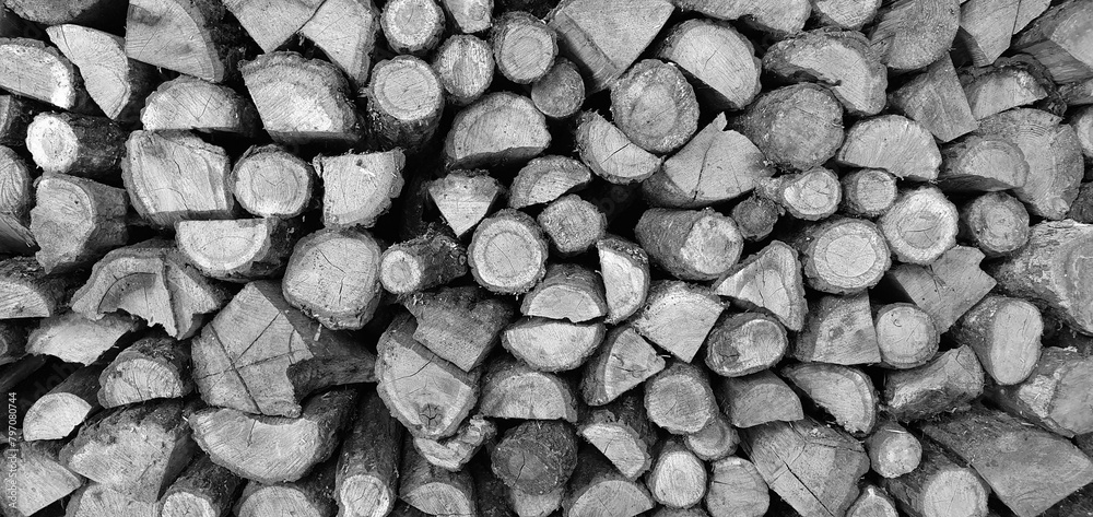 a lot of firewood stacked against the wall, wooden texture background a lot of firewood stacked against the wall, wooden texture background