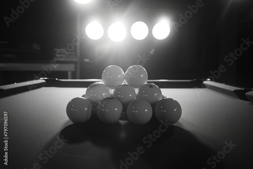 A monochrome photo of pool balls on a wooden table