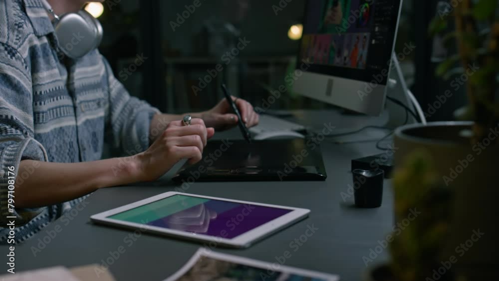 Medium of midsection and hands of female freelance retoucher sitting in home studio at desk with computer, working on commercial images or footage, drawing with stylus pen and digital graphic tablet