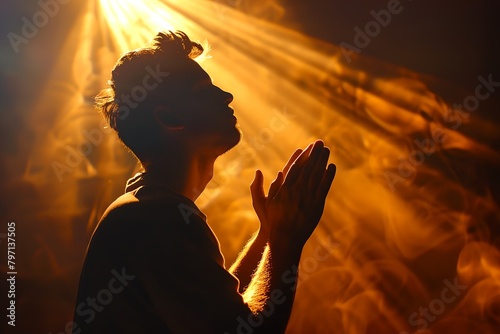 a person with a hat on and hands in the air with a light shining behind them and a person with a hat on photo
