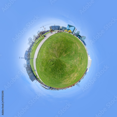 panorama of Spreebogen park in Berlin with government buildings in Berlin in early morning light in tiny planet format photo