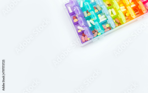 Different tablets in plastic pillbox on white background. Concept of schedule for taking medications. Selective focus, place for text