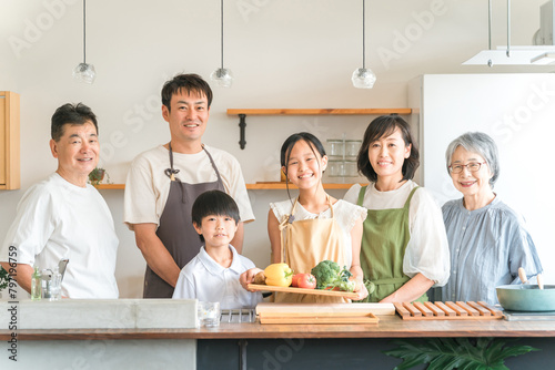 家のキッチンで子供と一緒に料理・クッキングする三世代家族・夫婦・親子（野菜・健康・栄養） 