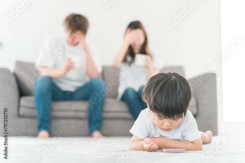 子供のスマホ依存に悩む・困る若いアジア人夫婦（スマホ育児） 