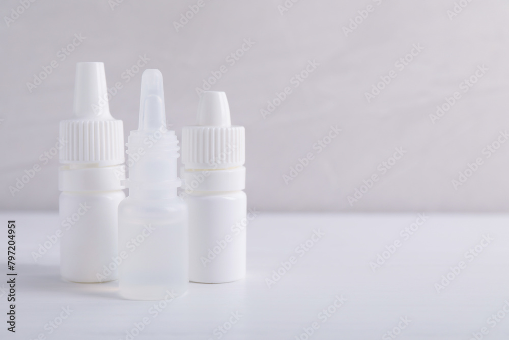 Bottles of medical drops on white background, space for text Bottles of medical drops on white background, space for text