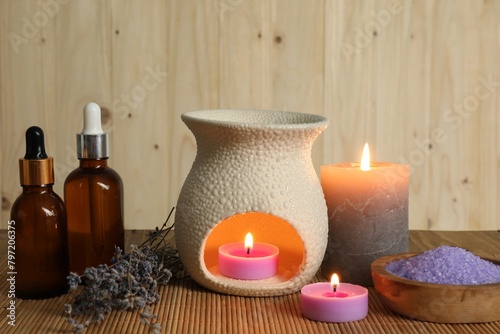 Aromatherapy. Scented candles  bottles  lavender and sea salt on bamboo mat