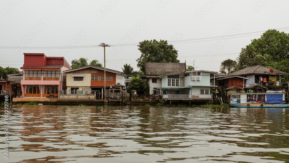 A row of colorful houses sits on the edge of a body of water. A row of colorful houses sits on the edge of a body of water.