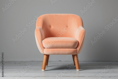 Modern Velour Chair Peach Fuzz, color of the year 2024 on wooden legs, grey background photo