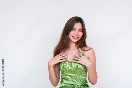 Beautiful young woman in a light green silk dress feeling joyful, isolated on white