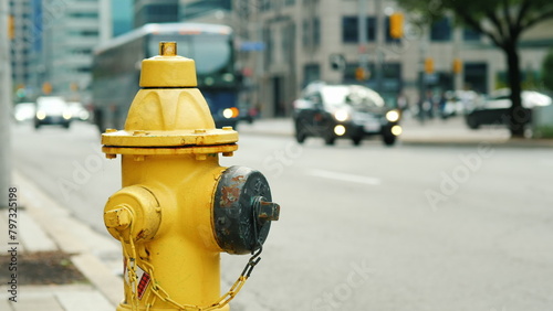 Yellow fire hydrant. In the background, the blurred busy Toronto street