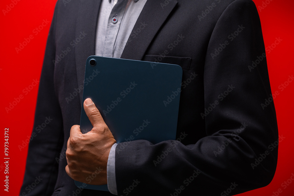 Close up hands of businessman using digital tablet device isolated on red background. Close up hands of businessman using digital tablet device isolated on red background.