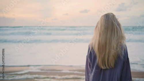 Ocean girl looking camera at beautiful sky closeup. Woman walking evening shore photo