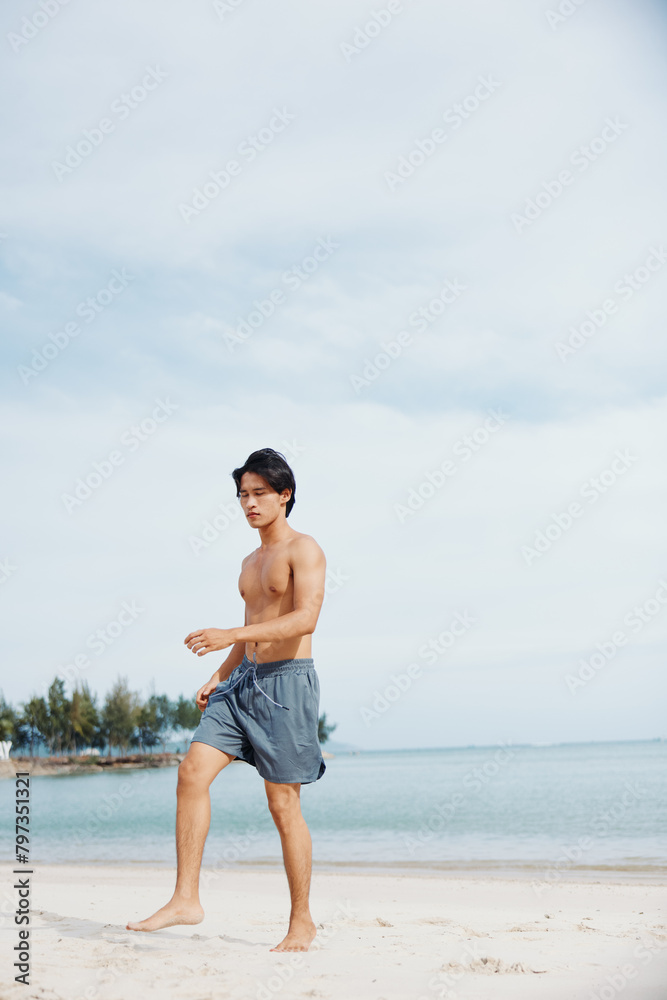 Active Asian Athlete Enjoying Beach Run at Sunset: Muscular Man Exuding Strength and Freedom.