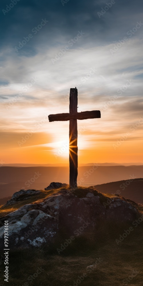 a cross on a hill with the sun shining through
