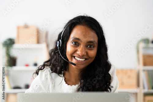 Portrait of insurance company Indian worker looking at camera. Woman wearing a headset.