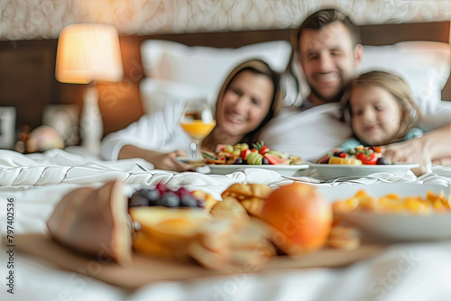 A happy family enjoys a luxurious breakfast in bed, with an assortment of delights ordered through room service photo