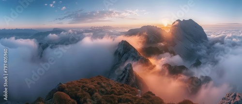A mountain range covered in clouds at sunrise.