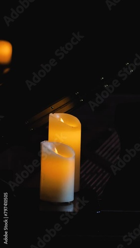 Two electric candles shot in the dark, the reflections from the smaller candle stand out, creating a tranquil atmosphere. Mourning, commemoration and grief for an irrevocable loss photo