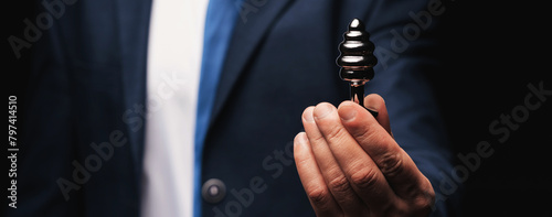 metal butt plug in a man's hand. The concept of anal sex. Wide horizontal banner header photo