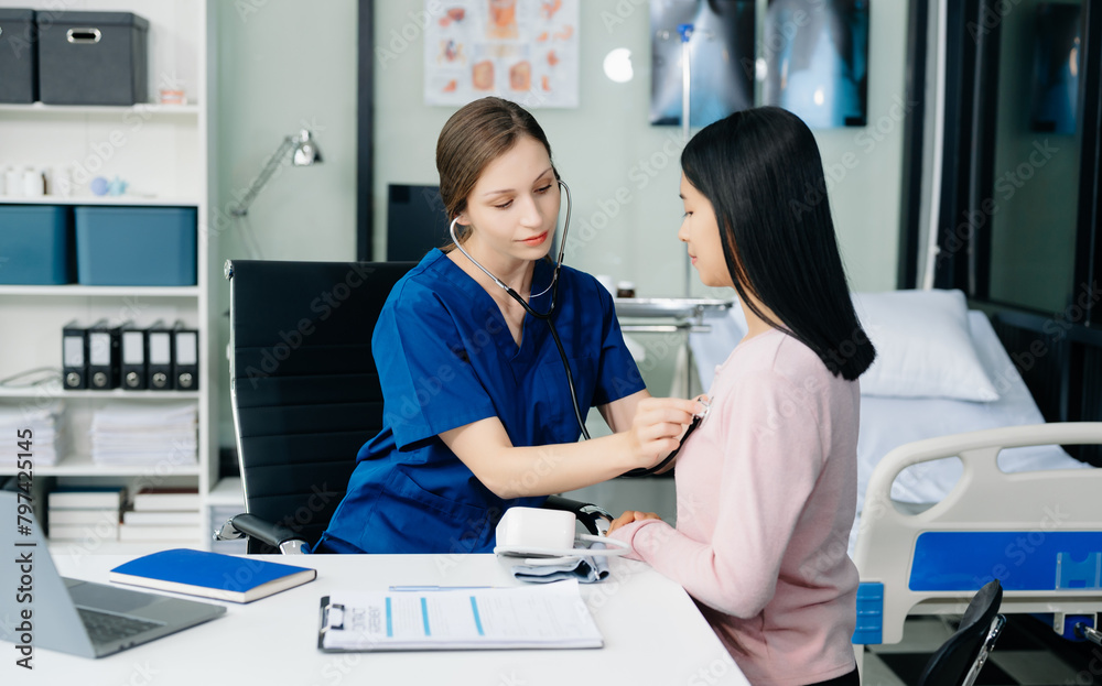 Obraz premium Doctor discussing treatment with Female patient talks to discuss results or symptoms and sitting on examination desk