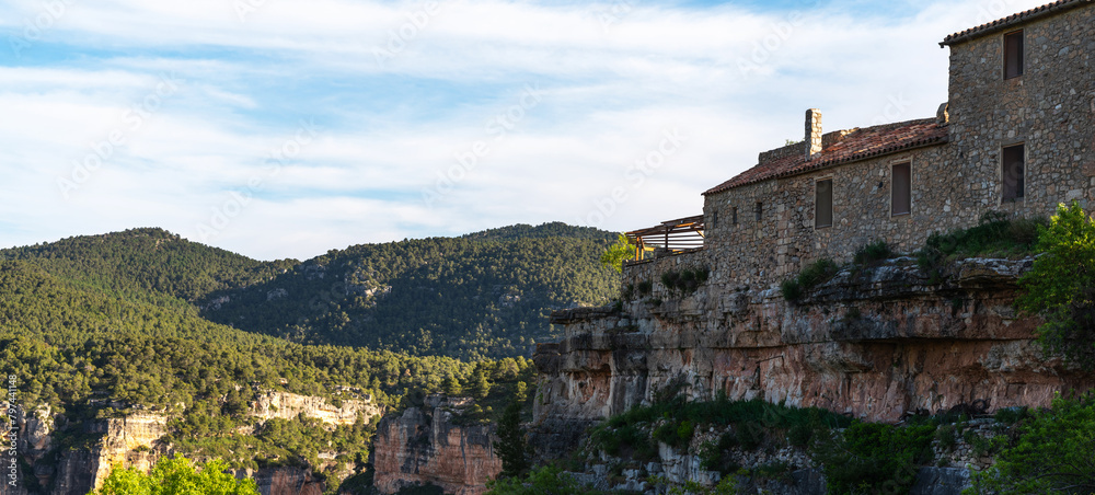 Old stone houses on a summer day with a blue sky. The picturesque medieval old town of Ciurana, Tarragona, Spain. It is located in a stunningly beautiful area with steep cliffs and a river.